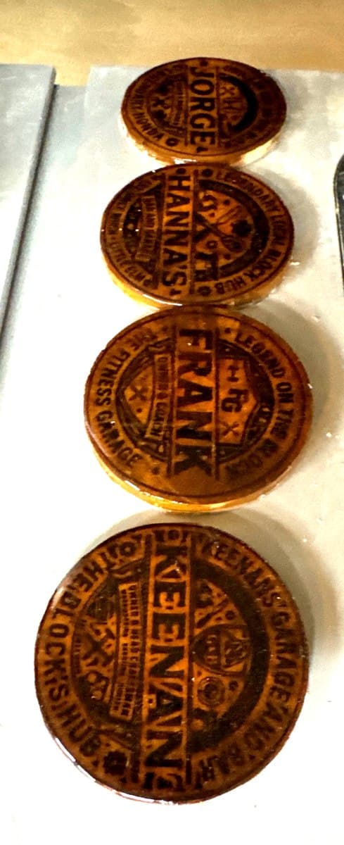 Four personalized coasters — Jorge, Hanna's, Frank, Keenan — with custom engravings and epoxy finish