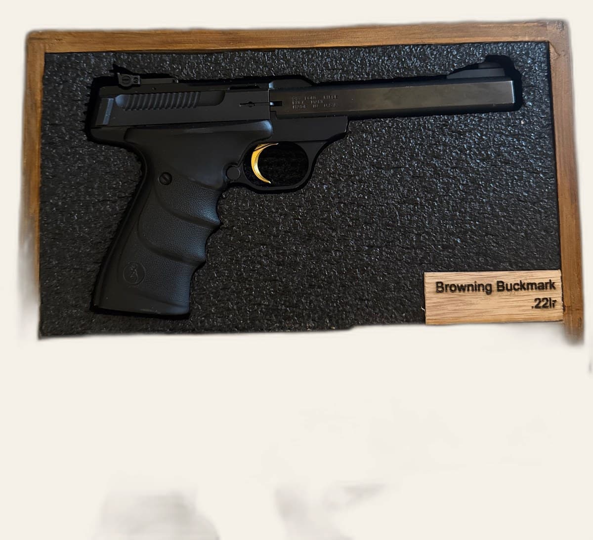Wooden gun display box open showing foam cutout and engraved nameplate