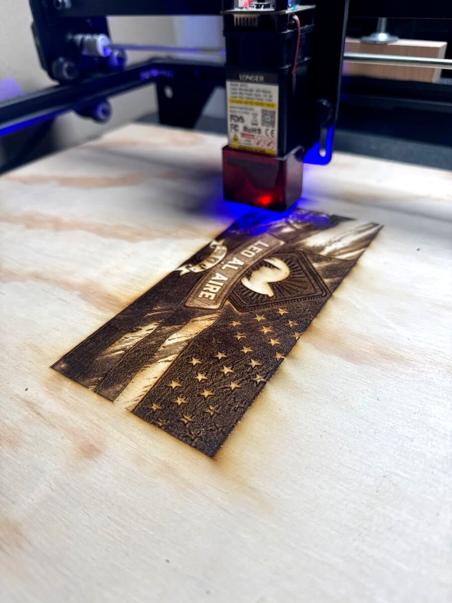 Laser engraver burning an American flag design — Leo Al Aire