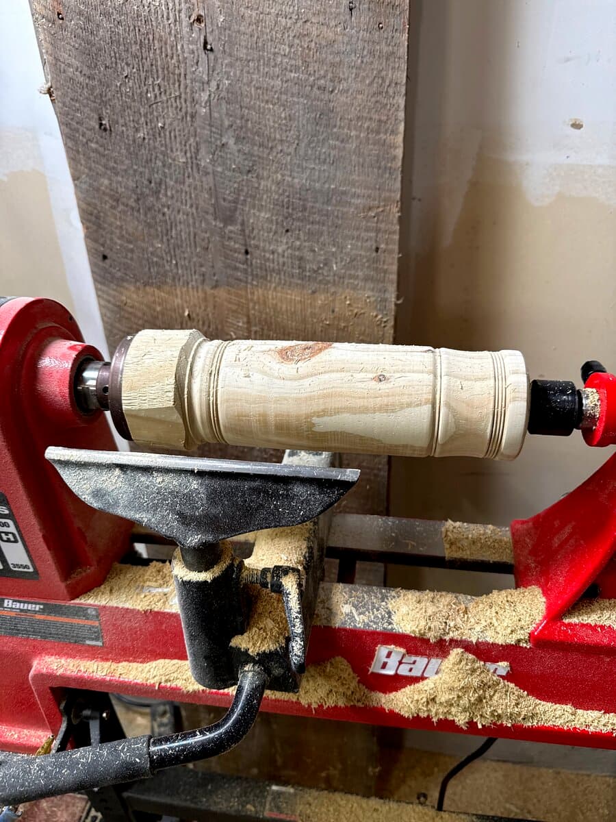 Large piece of wood being turned on the lathe with sawdust
