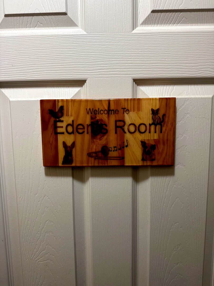 Eden's Room personalized door sign with custom icons hung on white door